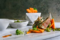 Рыба-скорпион с пюре и морковными палочками на мраморной тарелке — стоковое фото