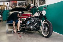 Mechanic repairing motorcycle — Stock Photo