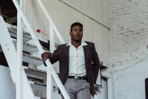 Schwarzer Mann steht auf Leiter — Stockfoto