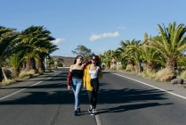 Donne che camminano su strada soleggiata — Foto stock