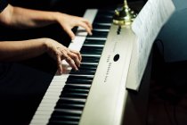 Seitenansicht der Schnitthände eines Musikers, der sitzt und E-Piano spielt. — Stockfoto