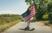 Mulher andando com bandeira americana — Fotografia de Stock