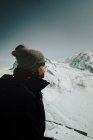 Vista laterale dell'uomo turistico in piedi sulle colline e distogliendo lo sguardo durante la giornata invernale, Cervino, Zermatt, Svizzera — Foto stock