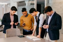 Büro-Team schaut aufs Smartphone — Stockfoto