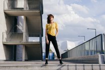 Donna sportiva in piedi di fronte all'edificio — Foto stock