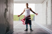 Uomo ispanico con le mani tatuate indossa abiti casual in piedi mostrando ripidità nel parcheggio sotterraneo — Foto stock
