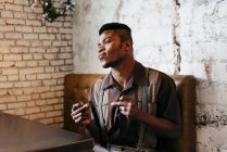 Человек в классической одежде сидит в кафе — стоковое фото