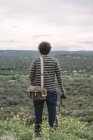 Uomo in piedi con macchina fotografica in natura — Foto stock