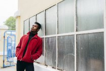 Schwarzer Mann lehnt an Glaswand — Stockfoto