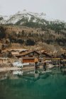 Houses at blue lake in mountains — Stock Photo