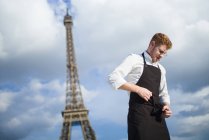 Rothaarige Köchin in Uniform vor dem Eiffelturm in Paris — Stockfoto