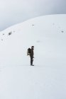 Турист с рюкзаком на снежной горе — стоковое фото