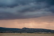 Pittoresca vista sul campo e sulle colline in nuvoloso sera grigia. — Foto stock