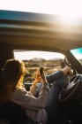 Woman using smartphone in car in nature — Stock Photo