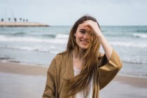 Портрет усміхненої дівчини, що стоїть на пляжі — стокове фото