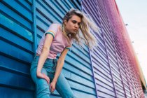 Блондинка молода жінка спирається на синю стіну на вулиці — стокове фото