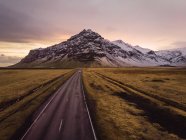 Estrada de asfalto na natureza com nuvens e montanhas, Islândia — Fotografia de Stock
