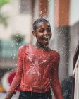 CAMEROON - AFRICA - APRIL 5, 2018: Ethnic girl standing under water drops — Stock Photo