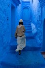 Femme marchant sur des escaliers dans une rue teinte en bleu, Maroc — Photo de stock