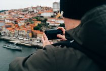 Чоловічий турист, беручи фотографії Старого міста з смартфон, порту, Португалія — стокове фото