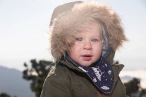 Portrait of Cute little boy in warm jacket standing in nature — Stock Photo