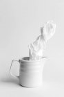 Wrinkled paper in ceramic mug on white background — Stock Photo