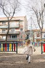 Блондинка біжить на дитячому майданчику в місті — стокове фото