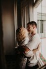 Casal feliz abraçando e vínculo em casa — Fotografia de Stock
