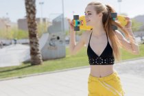 Blondes Mädchen steht mit Groschenbrett auf Gehweg — Stockfoto