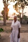 Angola - afrika - 5. april 2018 - fröhliche krankenschwester afrikanische frau steht am sonnigen abend und blickt in die kamera — Stockfoto