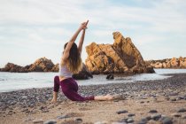 Подходят молодая женщина упражнения на пляже — стоковое фото