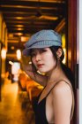 Porträt einer stilvollen asiatischen jungen Frau, die sich nachts in einem beleuchteten Restaurant an die Wand lehnt — Stockfoto