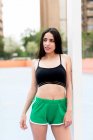 Attraktive schlanke Frau in Sportkleidung, die draußen steht und wegschaut — Stockfoto