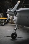 Close-up of airscrew on nose cone of small plane in hangar — Stock Photo