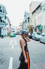 Lächelnde junge asiatische Frau, die auf der Straße in der Stadt läuft und in die Kamera schaut — Stockfoto