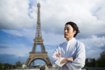 Japanese chef with arms crossed standing in front of Eiffel Tower in Paris — Stock Photo