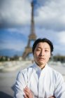 Японський шеф-кухар з обіймами перетнув стоячи перед Ейфелеву вежу в Парижі — стокове фото