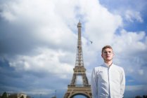 Уверенный рыжий повар в белой рубашке стоит перед Эйфелевой башней в Париже — стоковое фото