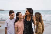 Donna sorridente adolescenti che si abbracciano insieme in riva al mare — Foto stock