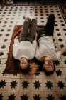 Jovem casal deitado no tapete com os olhos fechados em casa — Fotografia de Stock