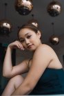 Retrato de joven asiática mujer sentado en moderno apartamento - foto de stock