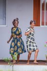 АНГОЛА - АФРИКА - 5 апреля 2018 года - Улыбающиеся молодые чернокожие женщины веселятся и танцуют дома на открытом воздухе — стоковое фото