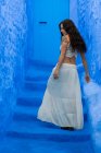 Visão traseira da mulher andando em escadas azuis — Fotografia de Stock