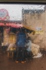 Ethnische Person steht an regnerischem Tag auf Dorfstraße — Stockfoto