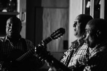 Кубинское музыкальное трио, действующее в ночном клубе, черно-белый кадр с длительной экспозицией — стоковое фото