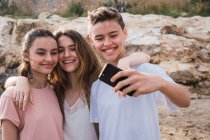 Smiling teenagers taking selfie on seashore — Stock Photo