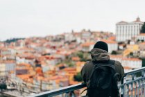 Male tourist looking at city view with orange roofs, Porto, Portugal — Stock Photo