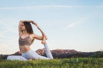 Femme étirant et faisant du yoga dans la nature — Photo de stock