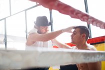 Hände eines nicht erkennbaren Sanitäters kontrollieren das Auge des Boxers im Boxring. — Stockfoto