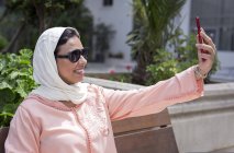 Марокканські жінка з хіджаб і типовий арабський плаття беручи selfie на відкритому повітрі — стокове фото